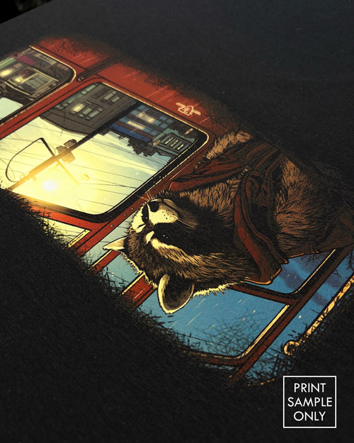 Close-up of a sample print on black fabric: raccoon on a streetcar, angled view (print sample only)