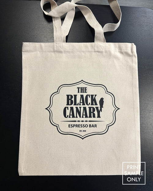 Sample print on a natural canvas tote bag: black crest logo (print sample only)