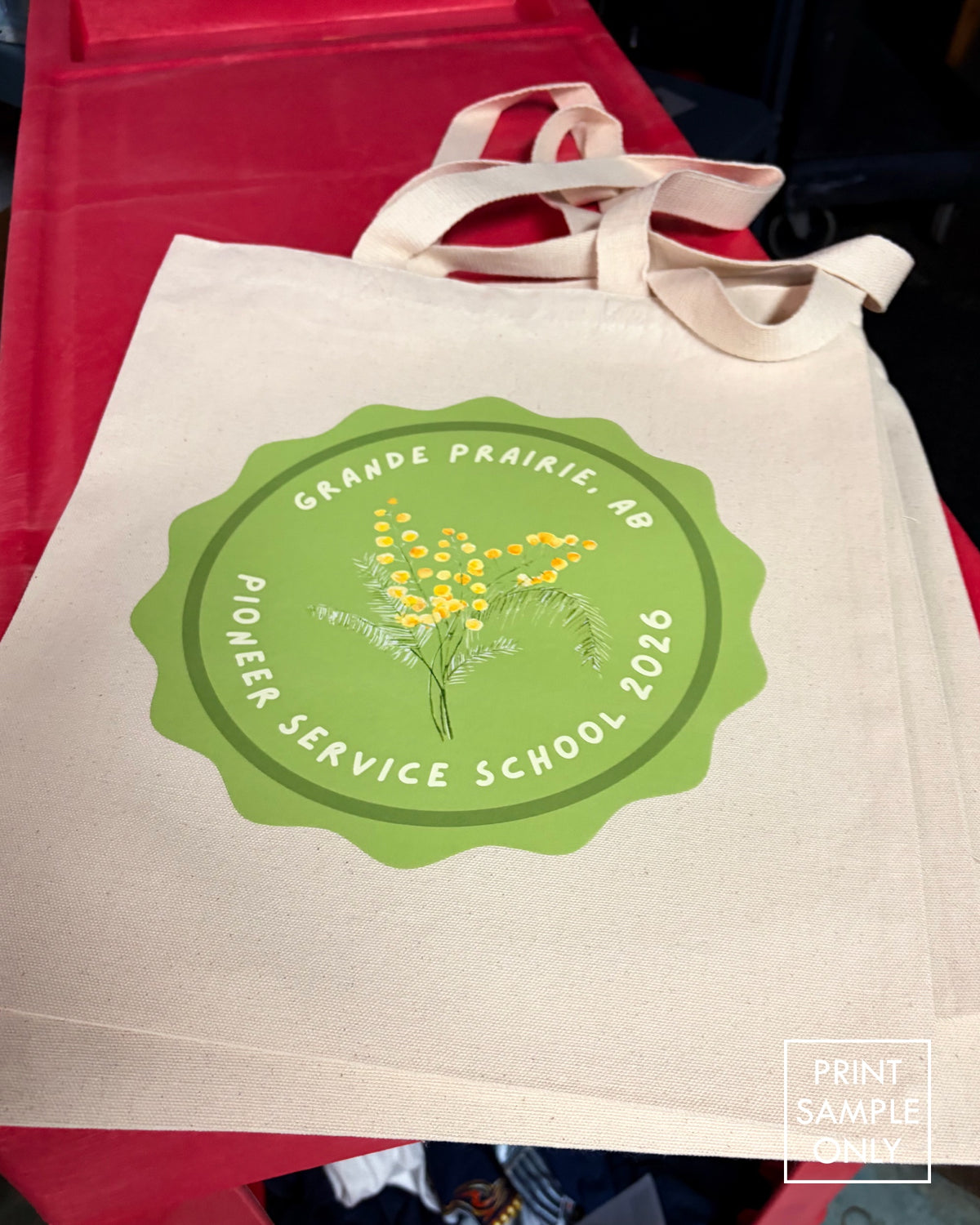 Sample print on natural canvas tote bags: green badge logo (print sample only)